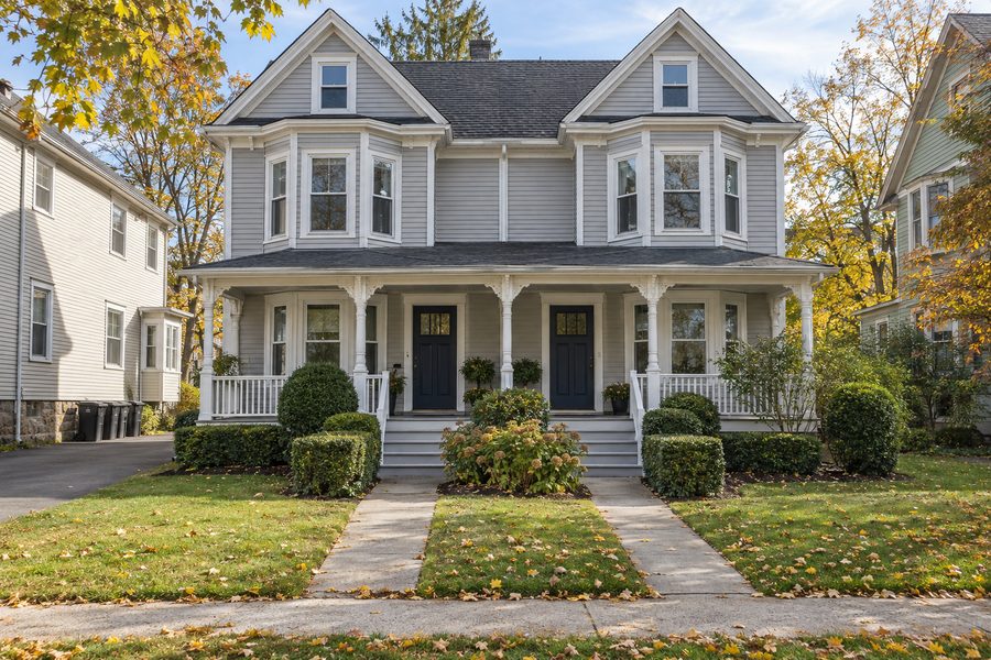A well-kept two-family house with a shared front porch and neat lawn